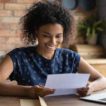 young woman reviews a printed job references at her desk